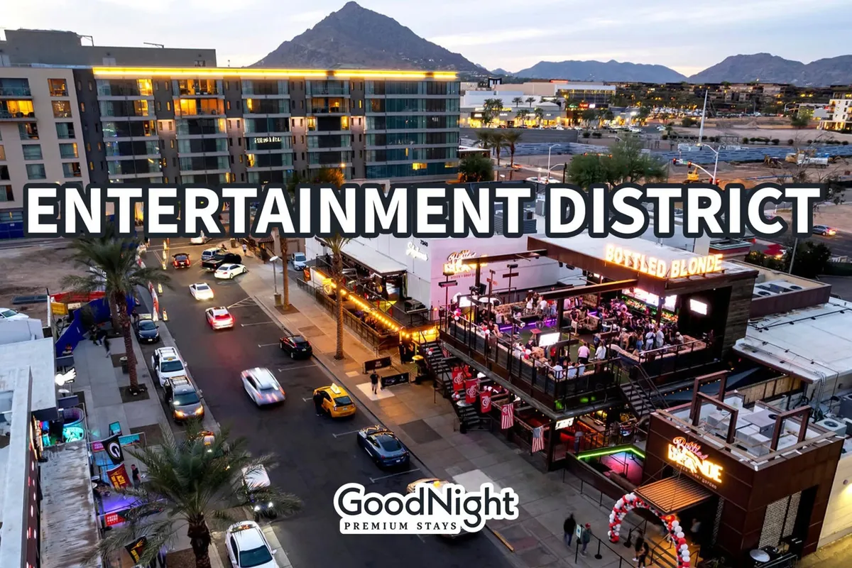 An exterior street scene with lively entertainment venues, busy sidewalks, and a dramatic mountain backdrop. The setting is alive with people enjoying dining, shopping, and Scottsdale's bustling social atmosphere at night.